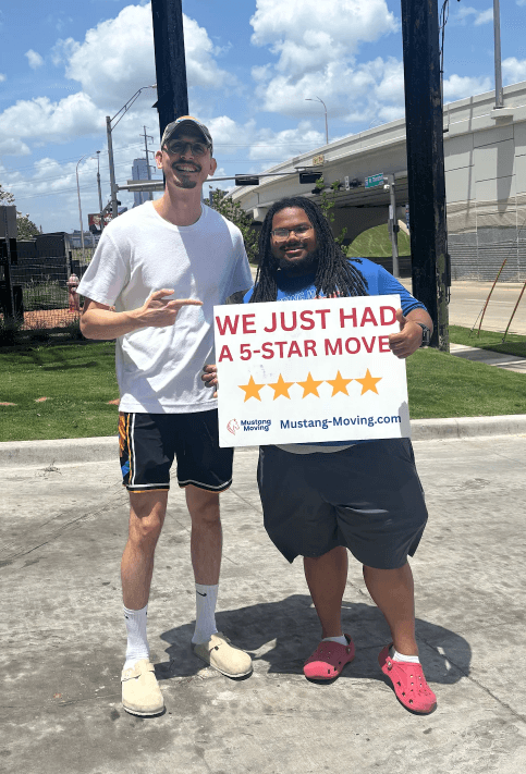 Mustang Moving customer Aaron W. with a crew member near a Dallas highway overpass.