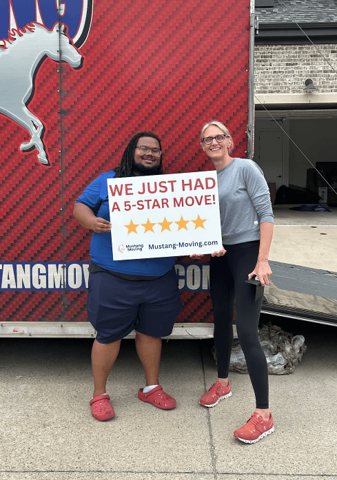 Mustang Moving customer Dana O. with a crew member in front of a Mustang Moving truck.