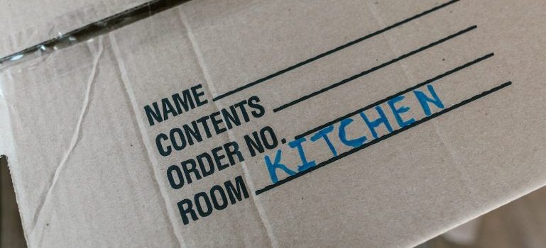 A box provided by Flower Mound movers with the word ''kitchen'' written on it.