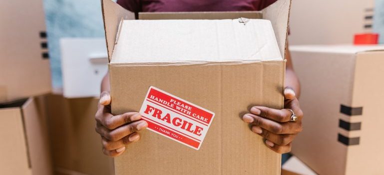 A member of the Denton movers team holding a box with fragile contents.