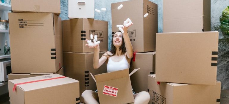 A woman playing with packing peanuts after having a seamless relocation with University Park movers.